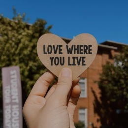 a person holding a heart that says love where you live