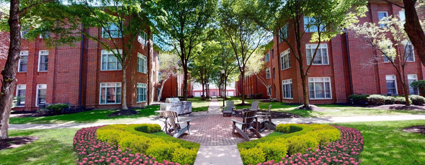a brick building with a courtyard and benches in front of it