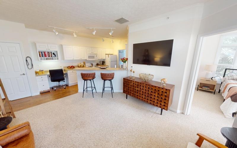 a living room with a tv and chairs